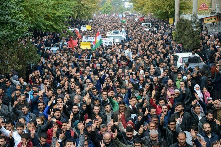 Hundreds of mourners follow a vehicle transports the coffin of killed Kurdish Lawyer Tahir Elci during his funeral the day after his assassination in Diyarbakir, on November 29, 2015. Elci, a leading Kurdish lawyer was shot dead in southeast Turkey after unknown attackers opened fire on a gathering in the mainly Kurdish province of Diyarbakir, triggering a shootout with police, local officials and witnesses said. AFP PHOTO / ILYAS AKENGIN / AFP / ILYAS AKENGIN
