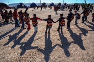 03. Syrian refugee children hold hands and form a ring while playing a game between classes in Adiyaman, which is one of 17 camps in Turkey.