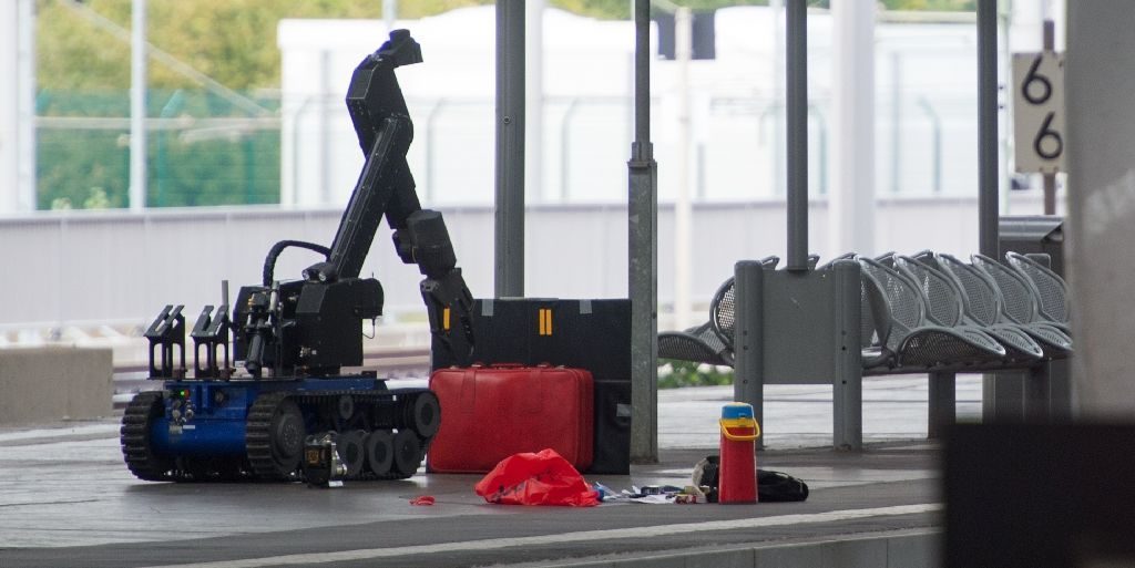 A remote controlled robot for bomb disposal lifts a suitcase standing on a platform of the train station in Chemnitz, eastern Germany, on October 8, 2016